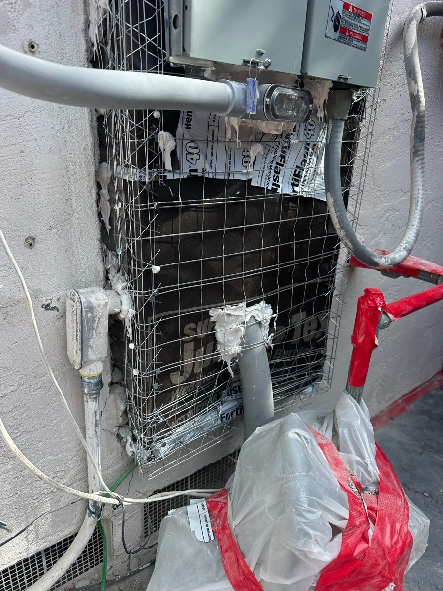 Weather-resistive paper and metal lath prepared around protected electrical service equipment