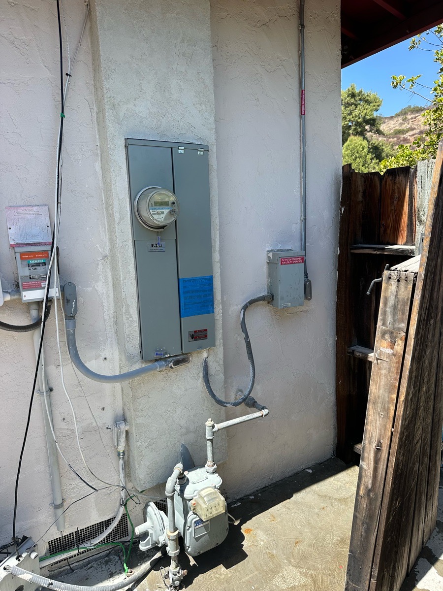 Restored unpainted stucco surrounding protected electrical service equipment